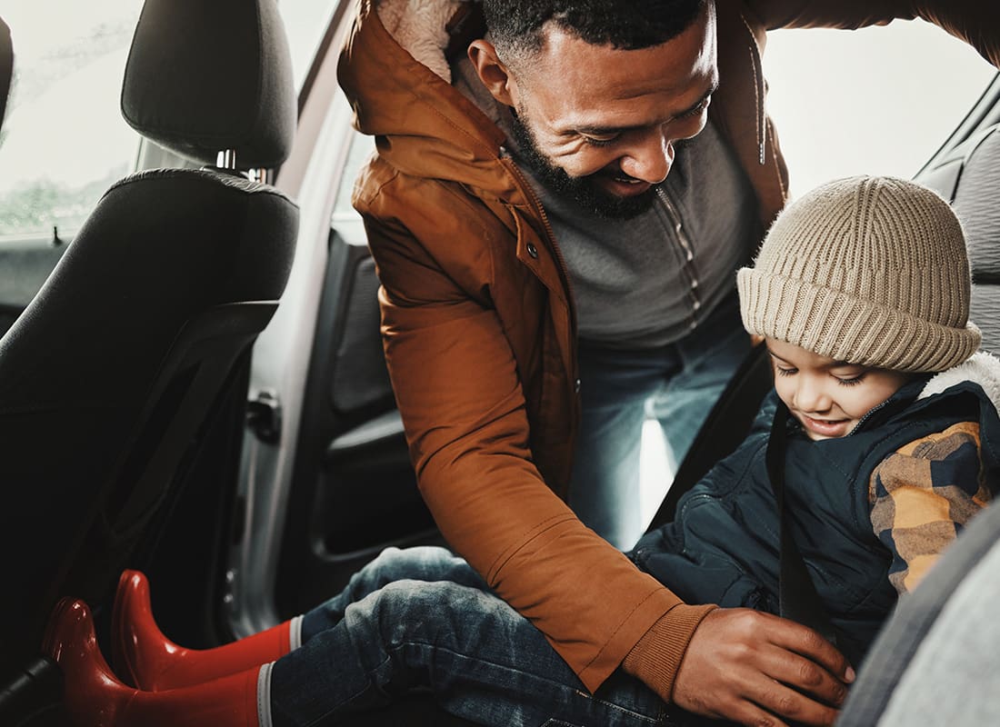 Personal Insurance - Father Helps Son With Carseat